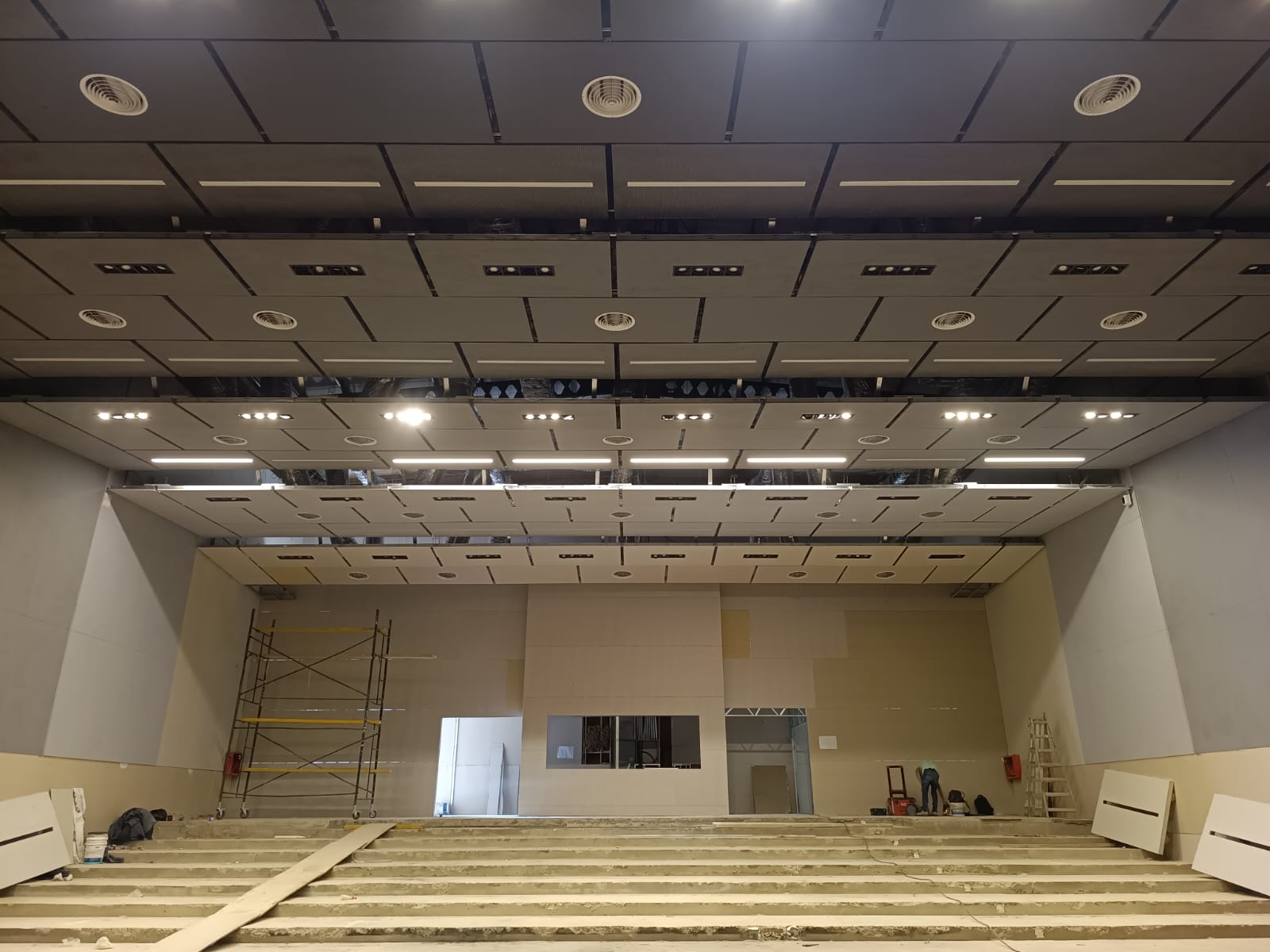 Auditorio en obra con cielorraso suspendido, luminarias y difusores